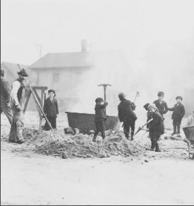 Children digging with pick axes on a Chicago street. Description: Children digging with pick axes on a Chicago street; Chicago, IL. Source: ICHi-52108. Chicago History Museum. Reproduction of photographic print, photographer unknown. Date: 1898.